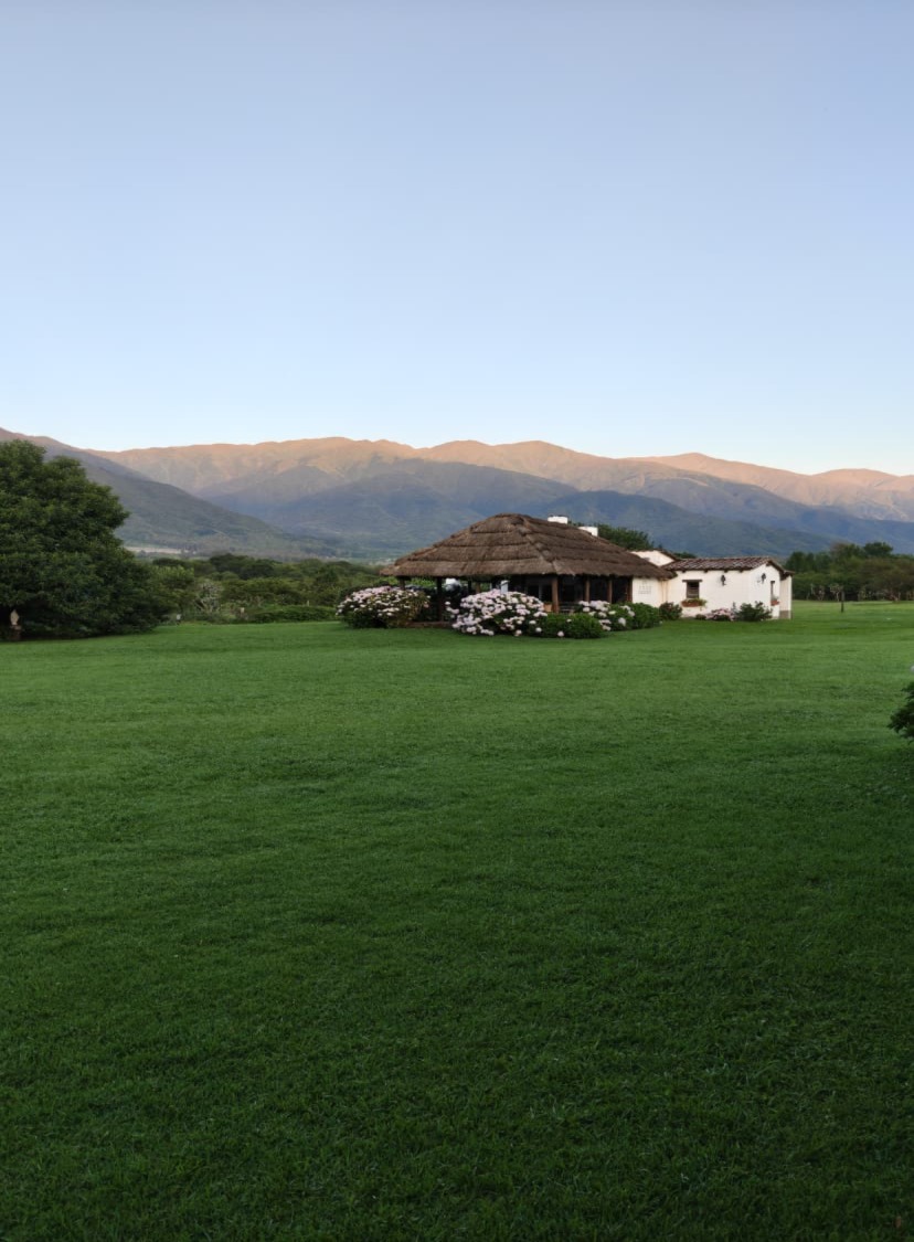 The farm in Salta where Ada and Ignacio will marry, with a white house and thatched roof set against green mountains